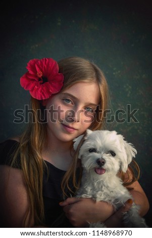 Blond kid girl with maltichon puppy pet dog and hibiscus red flower on hair