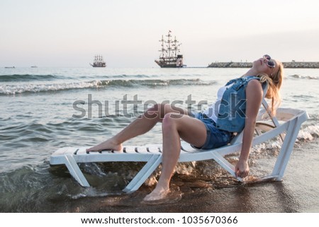 Blond teenager girl on the beach near sea or ocean