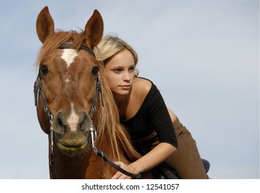 blond teenager and her brown horse in blue sky