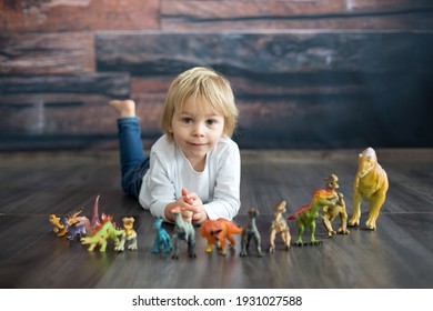 Blond Toddler Child, Playing With Dinosaurs At Home, Nice Soft Baclk Light