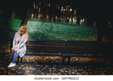 Blond Woman 45 Years Old Alone On A Walk In The Park In Autumn.