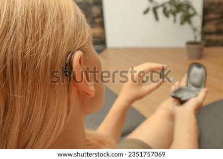 Image, Stock Photo Woman applying hearing aid to ear