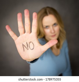 Blond woman expressing denial with NO written on her hand