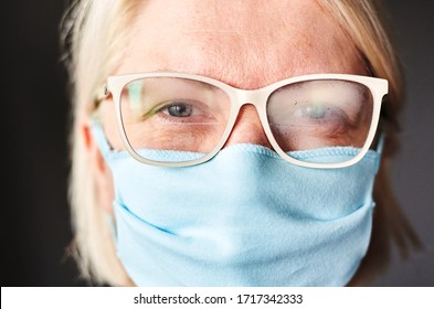 Blond Woman In Foggy Glasses And Antiviral Mask