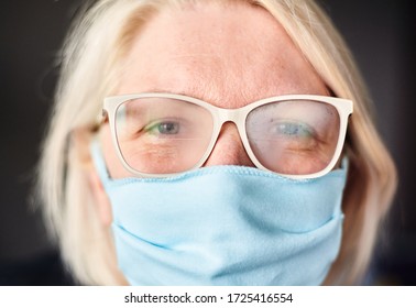 Blond Woman In Foggy Glasses And Antiviral Mask