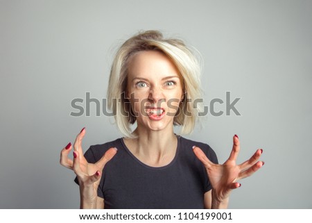 Blond woman growls in fury. Emotion concept