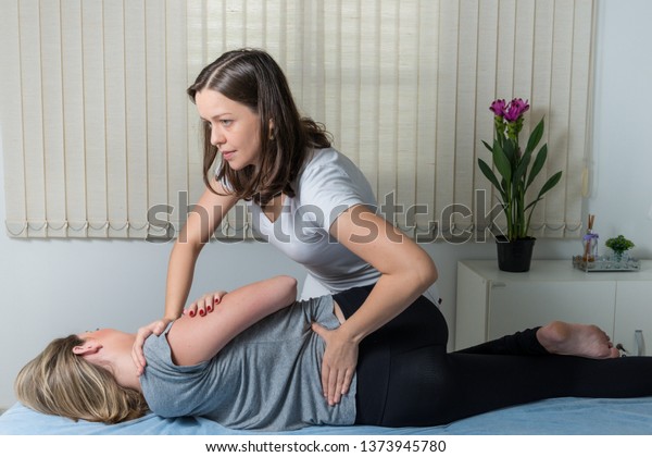 Blond Woman having chiropractic\
adjustment. Osteopathy, Alternative medicine, pain relief concept.\
Physiotherapy, sport injury\
rehabilitation.