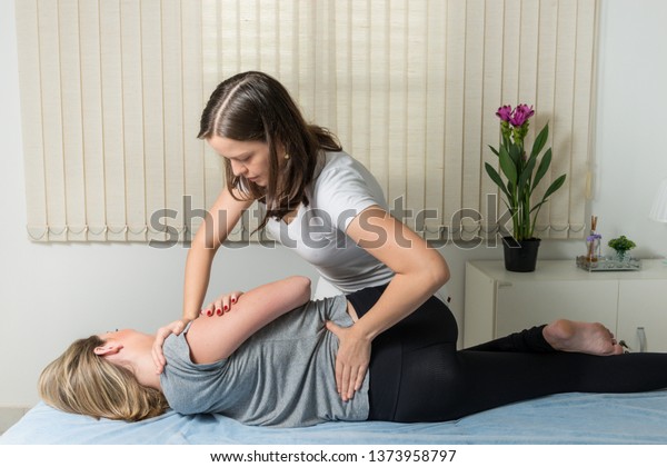 Blond Woman having chiropractic\
adjustment. Osteopathy, Alternative medicine, pain relief concept.\
Physiotherapy, sport injury\
rehabilitation.