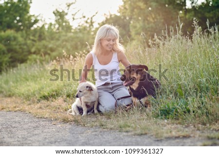 Similar – Image, Stock Photo Blond woman with her two dogs in the countryside