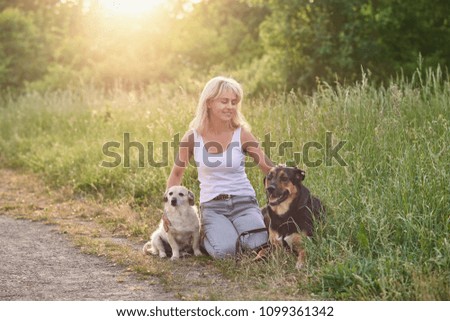 Image, Stock Photo Blond woman with her two dogs in the countryside