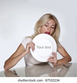 Blond Woman Licking Plate. Copy Space