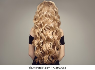 Blond Woman With Long Curly Beautiful Hair. Back View. 
