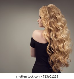 Blond Woman With Long Curly Beautiful Hair. Back View. 