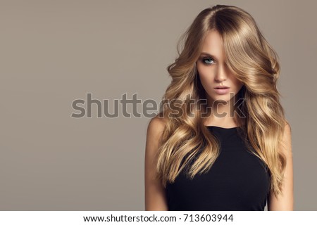 Blond woman with long curly beautiful hair. 