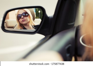 Blond Woman Looking In The Car Mirror