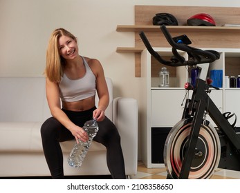 Blond Woman Riding Bike At Home Exercising For Their Legs And Cardio Training