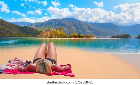 Blond woman sunbathing on the beach - Panoramic view of amazing Oludeniz Beach And Blue Lagoon, Oludeniz beach is best beaches in Turkey - Fethiye, Turkey