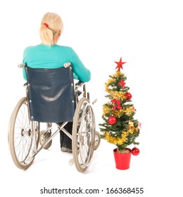 Blond Woman In Wheel Chair With Christmas Tree Isolated Over White Background