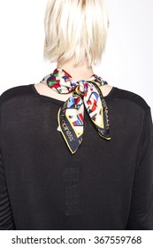 A blond woman(female, girl) wearing colorful scarf and black shirts back side isolated white at the studio.
