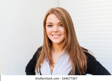 Blond women smiling, indoor head and shoulders image. Portrait Of A Pretty Happy Woman.    Close up portrait of a beautiful young american girl smiling and looking at camera. Copy space.