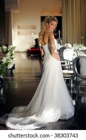 Blond Young Adult Bride Looking Over Shoulder At Wedding Reception Indoors.