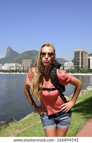 Blond young backpacker woman traveling at Rio de Janeiro with the Christ Redeemer in background.