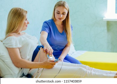 Blond young midwife examination belly of pretty blond pregnant woman with CTG scanning in practice. Pregnancy care. cardiotocography fetal heartbeat examination.
