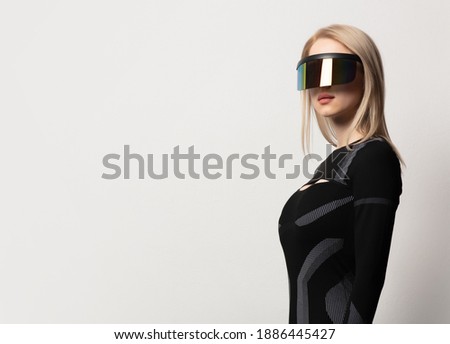 Blonde android female in VR glasses and suit on white background. 