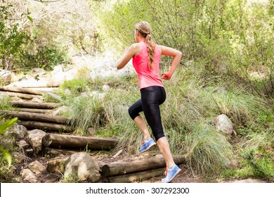 Blonde Athlete Running Up Wooden Stairs In The Nature