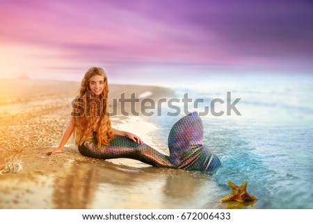 Blonde beautiful Siren Mermaid . Mermaid girl with pink tail  put feet in water. Top view. Fun, vacation concept. Text space