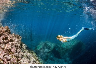 Blonde Beautiful Siren Mermaid While Diving Underwater In The Deep Blue Sea