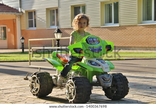 blonde boy goes for drive on electric quad bike. Tver\
Russia 2012. Sunny summer day. little girl rides his electric ATV\
quad. little boy of 5 years risk riding ATV quad bike in race\
track. quadbike 