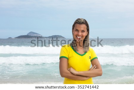 Blonde brazilian sports fan with crossed arms at beach