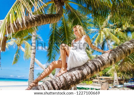 Blonde bride on the coconutpalm. Wedding and honeymoon on a tropical island. Summer vacation concept.