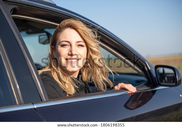 The\
blonde in the car. Attractive woman drives a\
car.