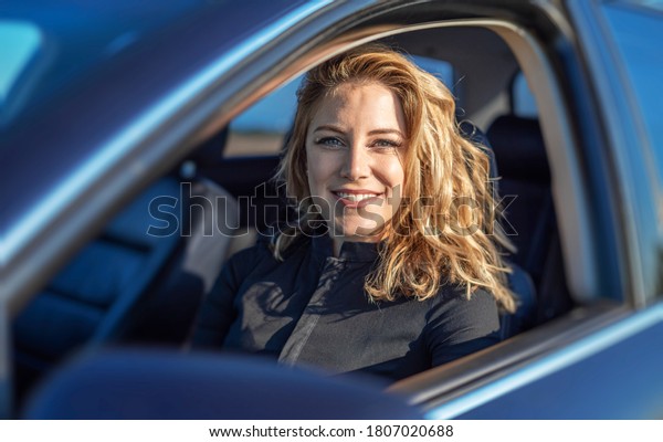 The\
blonde in the car. Attractive woman drives a\
car.