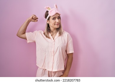 Blonde Caucasian Woman Wearing Sleep Mask And Pajama Strong Person Showing Arm Muscle, Confident And Proud Of Power 