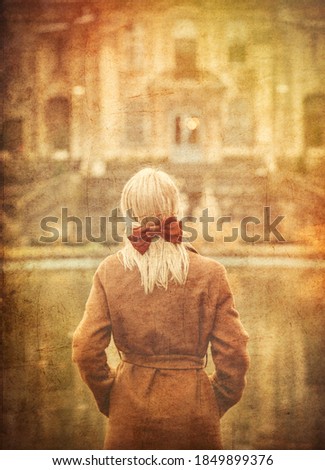 blonde in coat and bow with old castle on background. Image in old color style 