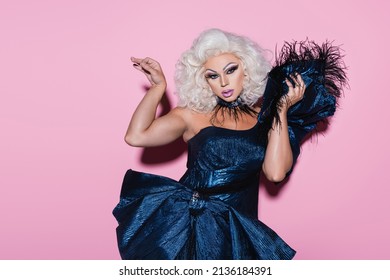 blonde drug queen in extravagant dress looking at camera while posing on pink - Shutterstock ID 2136184391
