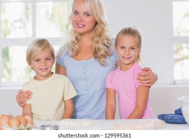 Blonde Family Smiling At The Camera With Baking Tools