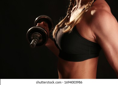 A Blonde Female Athlete With Boxer Braids Lifts Dumbbells In Training