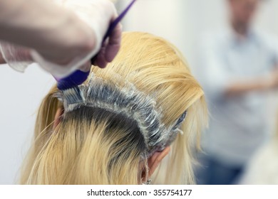 A  Blonde Female Bleaching Hair In Studio. Selective Focus