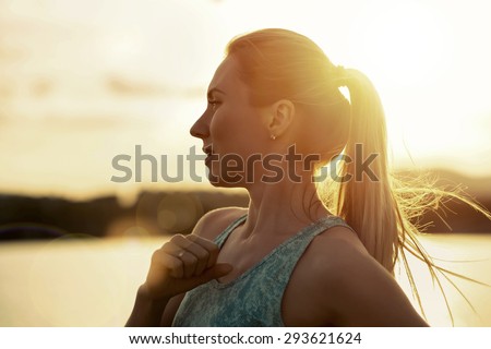 Blonde female running under sunlight