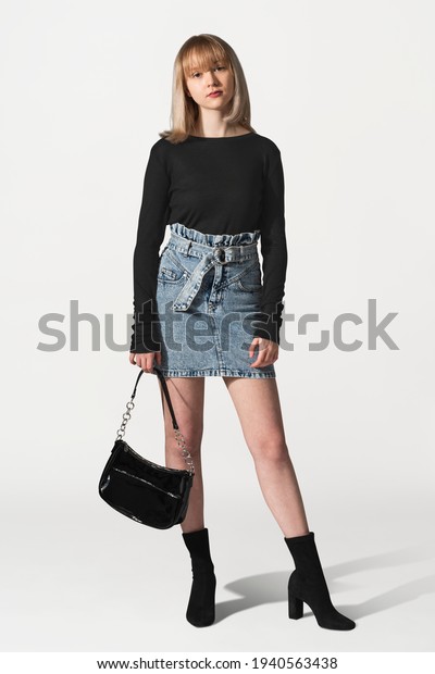 Blonde girl in black sweater and denim skirt for\
winter apparel shoot