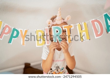 Blonde girl celebrating birthday with unicorn headband, cake, and making wishes. Close-up portraits with closed eyes, smiling, and mysterious gaze. Happy birthday concept, childhood joy, unicorn theme