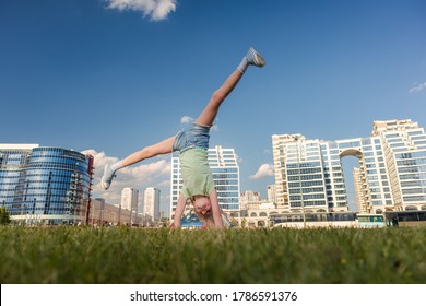 Blonde girl dancing, jumping, doing acrobatics and posing, in the city against the backdrop of buildings on a sunny day - Powered by Shutterstock