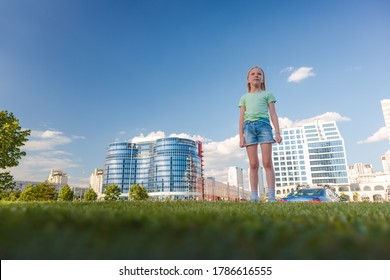 Blonde girl dancing, jumping, doing acrobatics and posing, in the city against the backdrop of buildings on a sunny day - Powered by Shutterstock