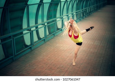 blonde girl with dreadlocks dancing in an empty pedestrian crossing 
