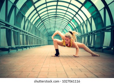 blonde girl with dreadlocks dancing in an empty pedestrian crossing 