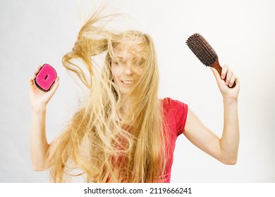 Blonde Girl Long Blowing Hair Holds Two Brushes, One With Natural Bristles. Haircare, Treatment Concept.